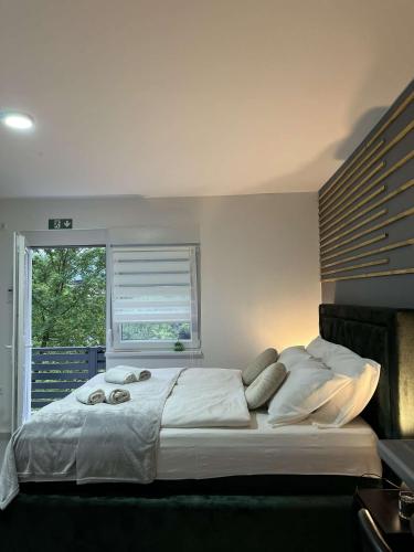 a large bed in a bedroom with a window at Apartments Indigo in Jajce