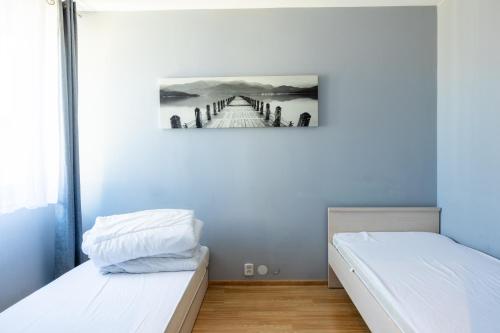 a room with two beds and a painting of a bridge at Apartament MonteCassino in Szczecin