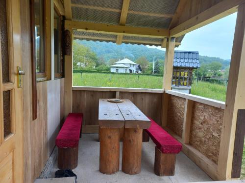 a porch with a wooden table and two benches at Садиба Федорчуків За рікою1 in Sheshory