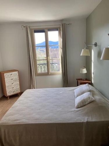 une chambre avec un grand lit et une fenêtre dans l'établissement Charmant appartement St Florent T4, à Saint-Florent