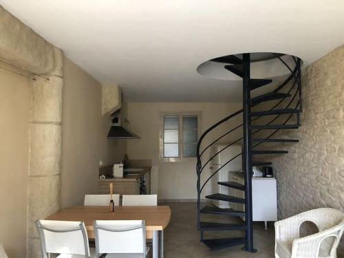 une chambre avec une table et un escalier en colimaçon dans l'établissement Charmant appartement St Florent T4, à Saint-Florent