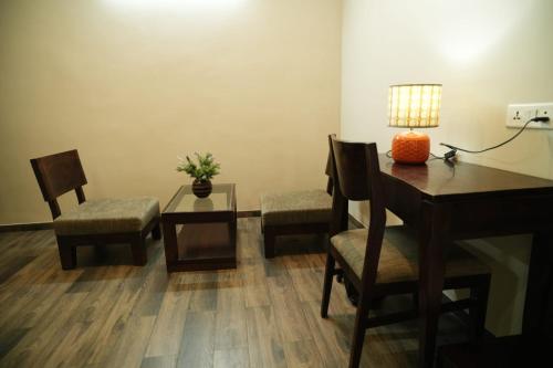 a living room with a table and chairs and a desk at HOTEL GRANDEUR in Valsad
