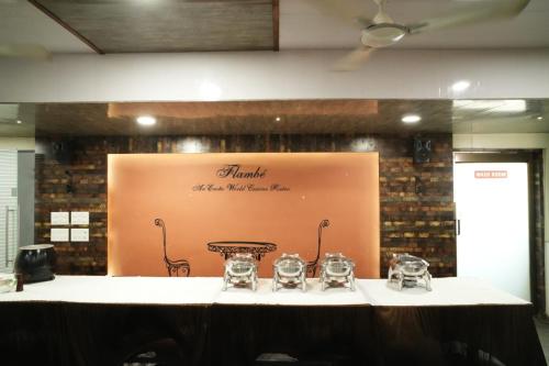 a table with wine glasses on top of it at HOTEL GRANDEUR in Valsad
