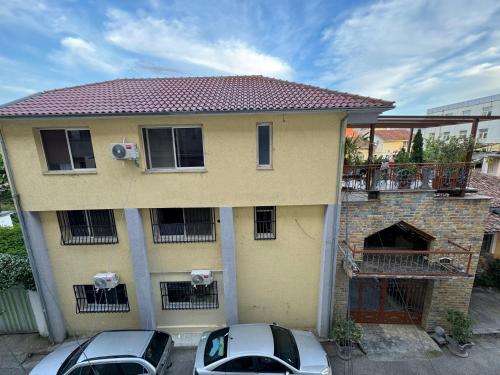 twee auto's geparkeerd voor een huis bij Shkodra Guest House in Shkodër