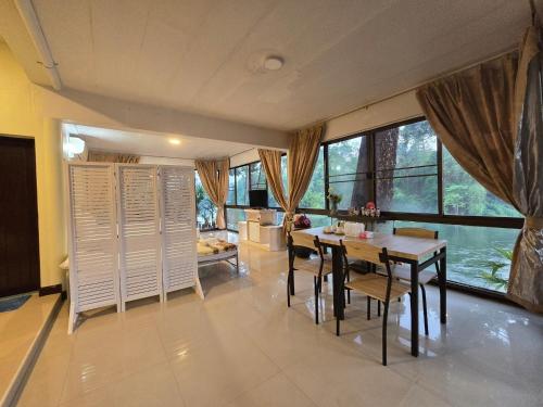 una cucina e una sala da pranzo con tavolo e sedie di Puprai Tarnnarm Resort a Thong Pha Phum
