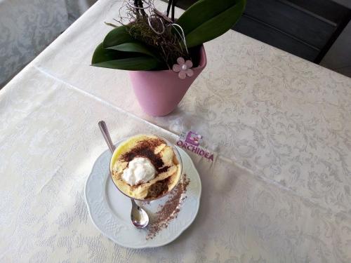 a cup of coffee on a plate on a table at Hotel Orchidea in Bardolino