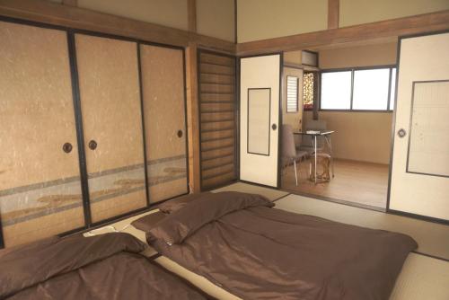 ein Schlafzimmer mit einem Bett in einem Zimmer in der Unterkunft Aioi Yanto 一日一組限定古民家宿 in Otaru