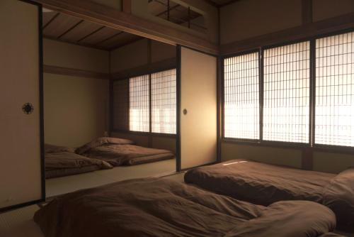 a room with two beds and two windows at Aioi Yanto 一日一組限定古民家宿 in Otaru