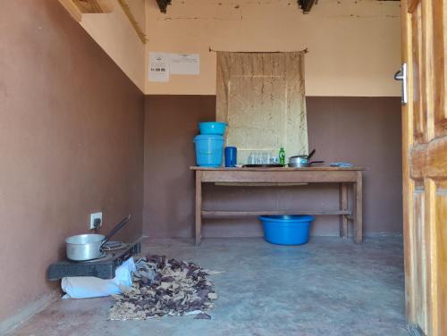 um quarto com uma mesa e panelas e frigideiras azuis em Simoonga Thandizani School em Livingstone