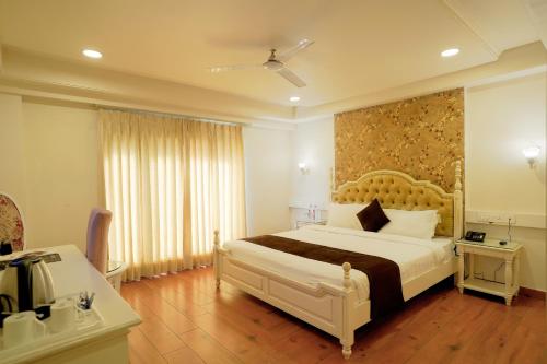 una camera con un grande letto e una grande finestra di Hotel Magenta Jaipur a Jaipur