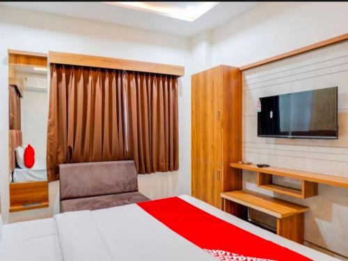 a bedroom with a bed and a flat screen tv at Hotel Hill View in Gandhinagar