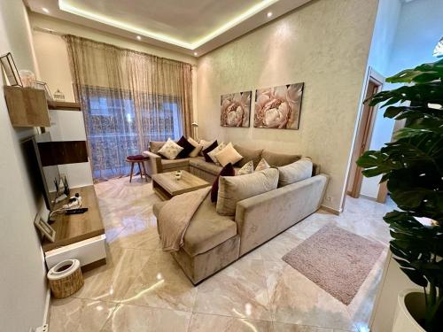 un soggiorno con divano e tavolo di Apparemment de luxe vue piscine a Bouznika