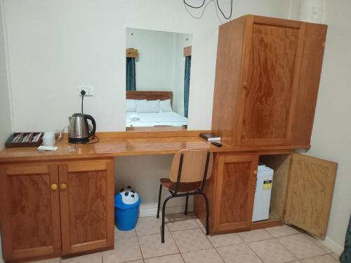 Habitación con escritorio de madera y cama en el espejo. en Sunset Lodge en Savusavu