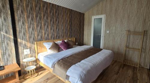 a bedroom with a large bed with purple pillows at Instaview Kanatal in Tehri-Garhwāl