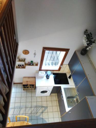 une cuisine avec un comptoir blanc et une fenêtre dans l'établissement le studio de Monta, à Vendays-Montalivet