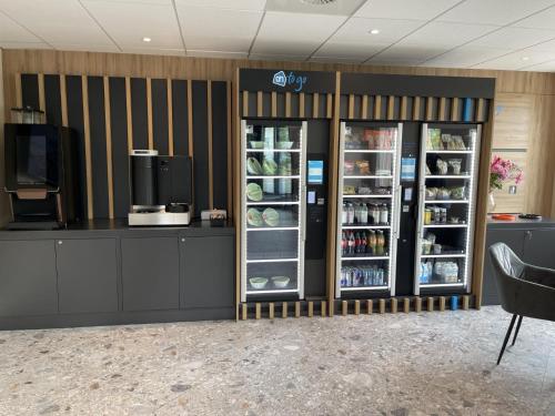 a store with two refrigerators and a counter with food at OZO Hotels Antares Airport in Hoofddorp