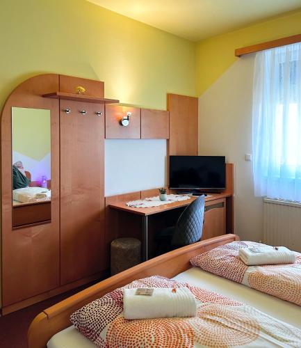 a small room with two beds and a desk at Frühstückspension Elena Nicoleta Caltun in Fischamend Dorf