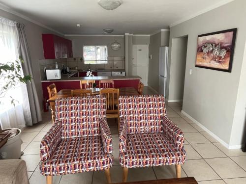 a living room with two chairs and a table at Beautiful 3 Bedroom Ground floor apartment - 66 Santini Village in Plettenberg Bay