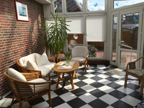 un patio con sedie e tavolo su un pavimento a scacchi di Haus - Neue Düne a Dankern