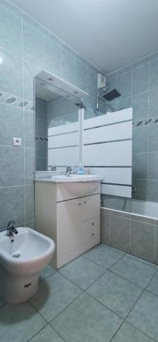 une salle de bain blanche avec un lavabo et un miroir dans l'établissement Villa Azzurra superbe 2P centrale et vu mer, à Menton