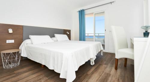 ein Schlafzimmer mit einem großen weißen Bett mit einem Fenster in der Unterkunft Es Sabina in Son Servera