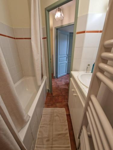une salle de bain avec une baignoire et un lavabo dans l'établissement Le Logis Saint Roch, à Pézenas