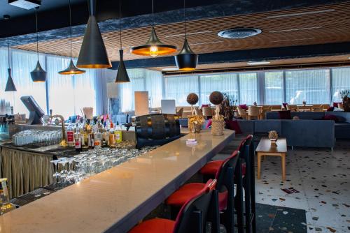 a bar in a restaurant with a long counter and chairs at Grand Hotel Sunny Beach - All Inclusive in Sunny Beach