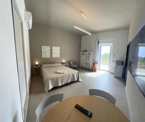1 dormitorio con 1 cama, 1 mesa y 1 perro en MP Luxury room en Budoni