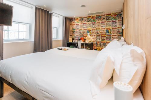 Un dormitorio con una gran cama blanca y una ventana en Grassmarket Hotel en Edimburgo