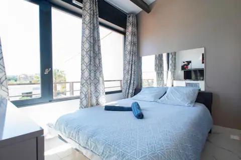 une chambre avec un lit et une grande fenêtre dans l'établissement Le Solarium - Piscine - 7 pers - Centre Port, au Cap d'Agde