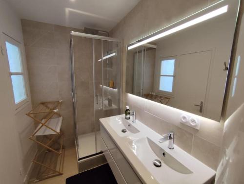 une salle de bain blanche avec un lavabo et une douche dans l'établissement Le Pic vert By Nid'Ouest 3 Chambres, à Quimper