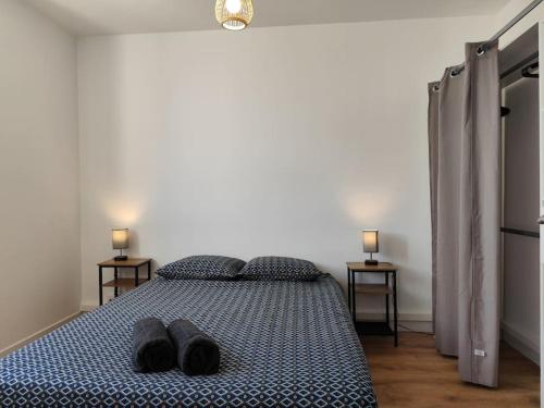 - une chambre avec un lit et des chaussons dans l'établissement Le Pic vert By Nid'Ouest 3 Chambres, à Quimper
