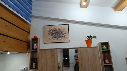 a painting on a wall above a kitchen cabinet at Nitro Inn 1 Premium Cozy - Wine Tasting - Souvenir - Art Gallery - Private Guided Tours - Relaxing - Romantic in Skopje
