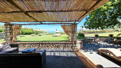 a patio with a large wooden pergola and a yard at Villa Maiora in Capri