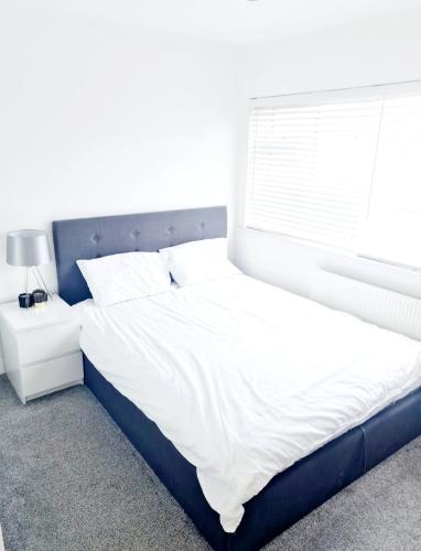 Un dormitorio con una cama grande con ventana. en 3 Bedroom House London, en Harrow