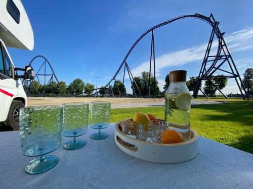 a table with glasses and a bottle and a roller coaster at Encar - Bliżej nie będzie in Zator