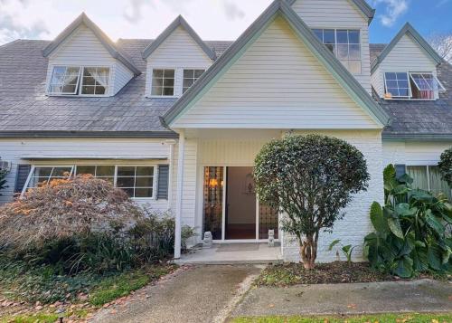 a white house with a door and a tree at 5Rooms life-style in City—“Golden Harvest Retreat” in Matangi