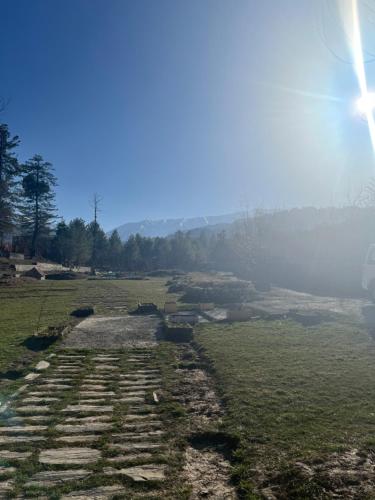 a field with a stone pathway in the grass at JK's The Trout Stream in Gulmarg