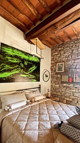 a bedroom with a bed and a stone wall at La Casa Stregatta in Sassetta