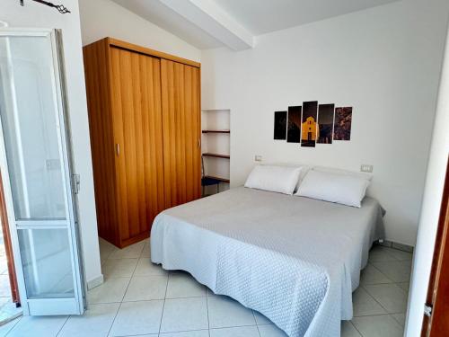 a bedroom with a bed and a wooden door at Casa Giliè A in Santa Maria Navarrese