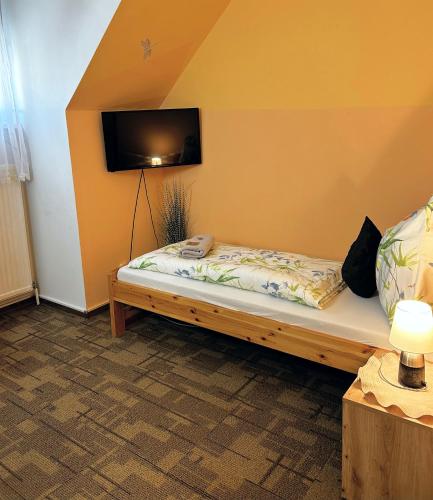 a bed in a room with a tv on the wall at Frühstückspension Elena Nicoleta Caltun in Fischamend Dorf