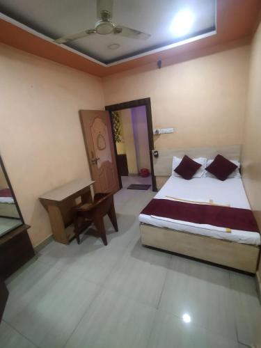 Un dormitorio con una cama y un escritorio. en Hotel Thakur Ji, en Bhopal