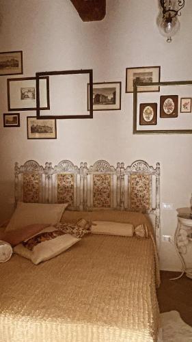 a bedroom with a large bed with aintage headboard at La Casa Stregatta in Sassetta