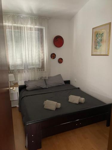 1 dormitorio con 1 cama con 2 toallas en Apartments Natasa, en Punat