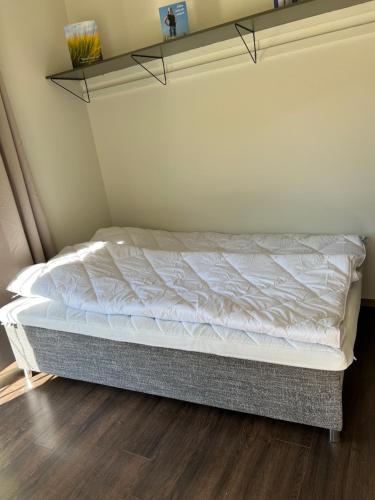 a bedroom with a bed with a white bedspread at Attefallare i äppelriket in Vånga