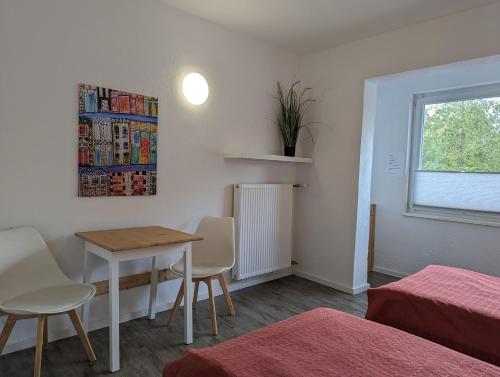 Gästehaus Koblenz Obergeschoss في فالندار: غرفة صغيرة مع طاولة وكراسي ونافذة