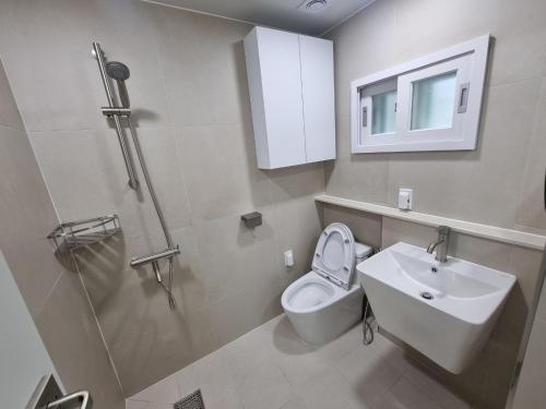 uma casa de banho com um WC, um lavatório e um chuveiro em Calmers em Pohang