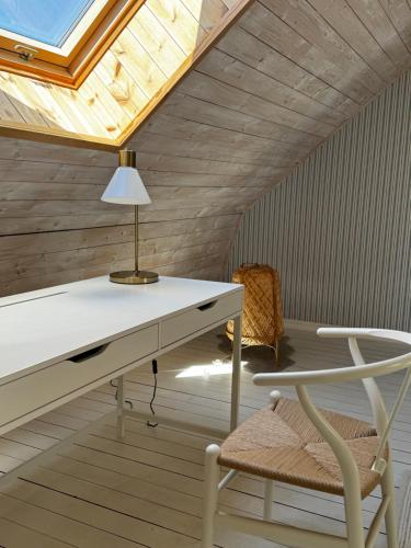 einen Schreibtisch mit einer Lampe und einem Stuhl in einem Zimmer in der Unterkunft Quadambra Park in Gärsnäs