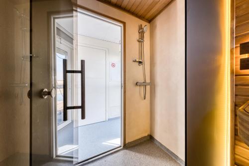 a glass door leading to a hallway with a door at Cozy Floating house with sauna in Tallinn