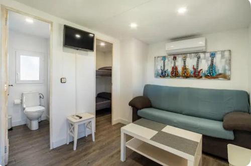 Apartamento en Bolonia في بولونيا: غرفة معيشة مع أريكة زرقاء وحمام